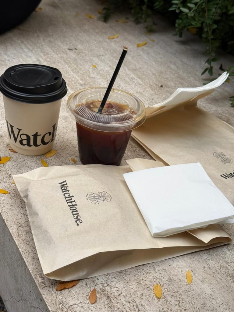 Takeaway coffees and a bag with a baked good in well designed packaging.