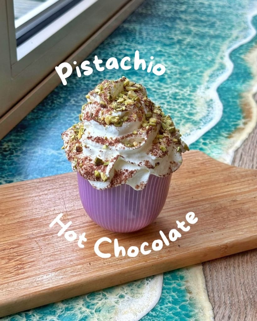 A pistachio flavoured hot chocolate with whipped cream and chocolate dust.