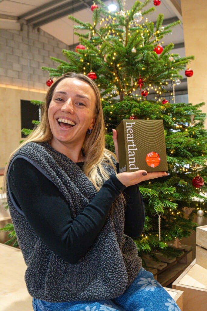Cafe owner holds bag of seasonal coffee from Heartland coffee roasters.